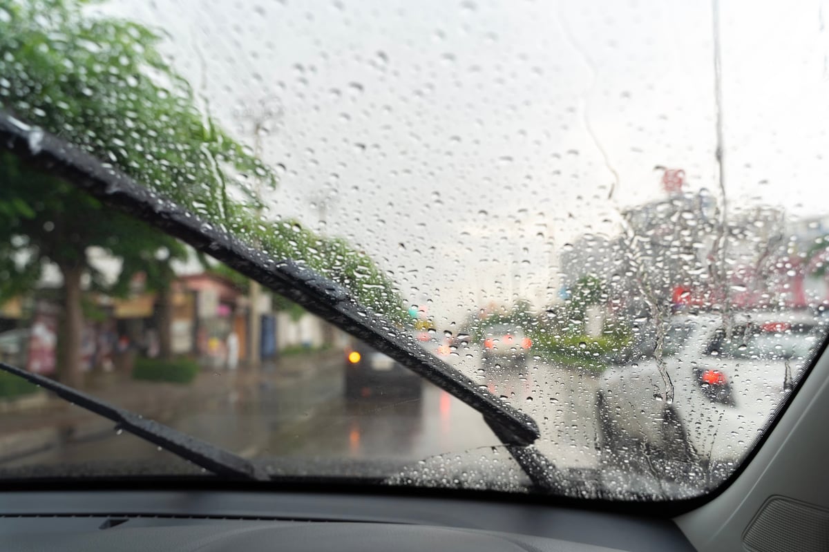 Car windshield with rain drops and wiper blade closeup