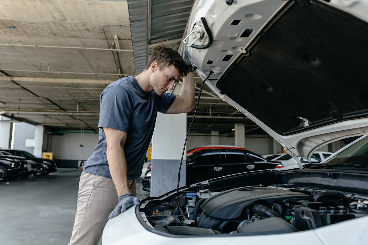Mechanic inspecting engine at garage workshop, Car auto services and maintenance check concept.